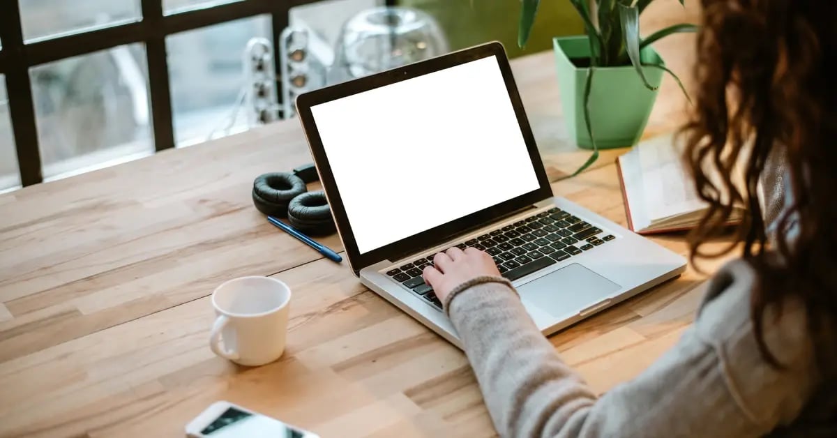 A female Executive Assistant writing at her desk on her laptop