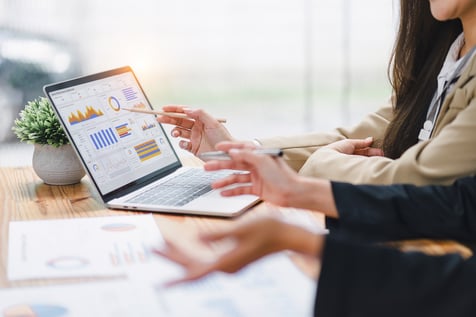 An Executive Assistant working with a colleague in front of a computer