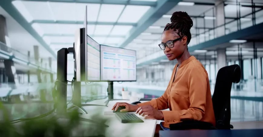 An Executive Assistant working in a well lit office looking at an excel sheet