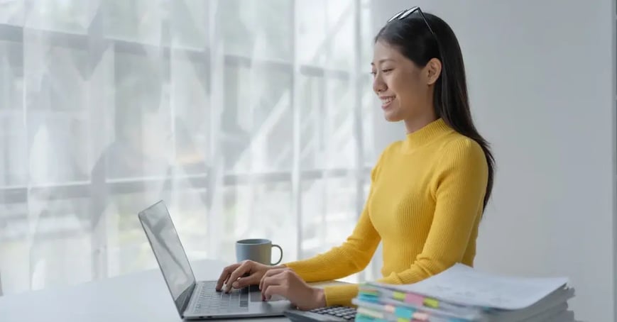 An Executive Assistant writing a meeting objective on her laptop