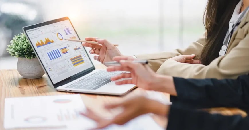 Data-Driven Executive Assistants looking at a report on a laptop