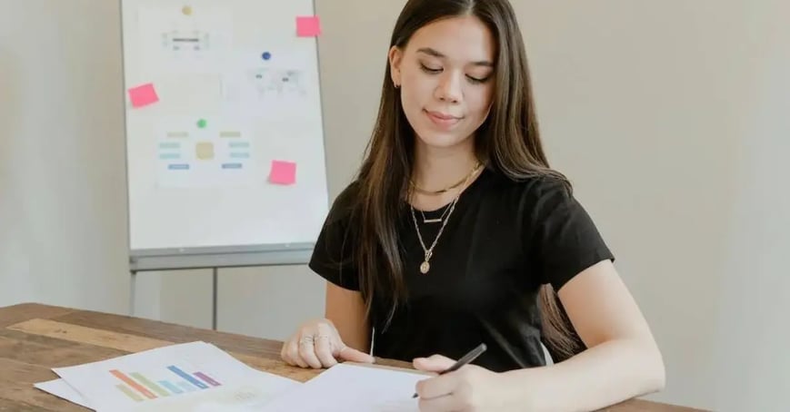 Female Executive Assistant writing in a notebook_